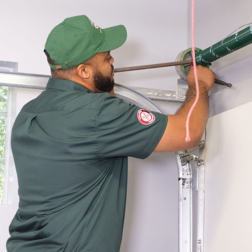 A Precision technician works on repairing a broken spring in a garage. 