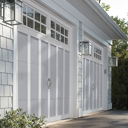 A gray and white carriage door with square windows.