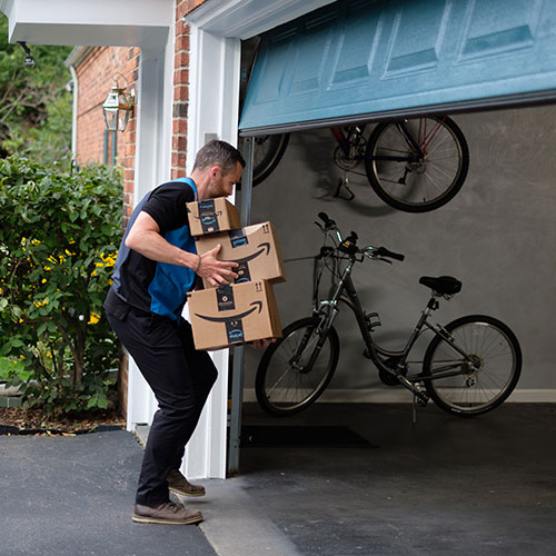 An Amazon delivery driver uses Key by Amazon to open the garage door and securely leave packages inside the garage. 